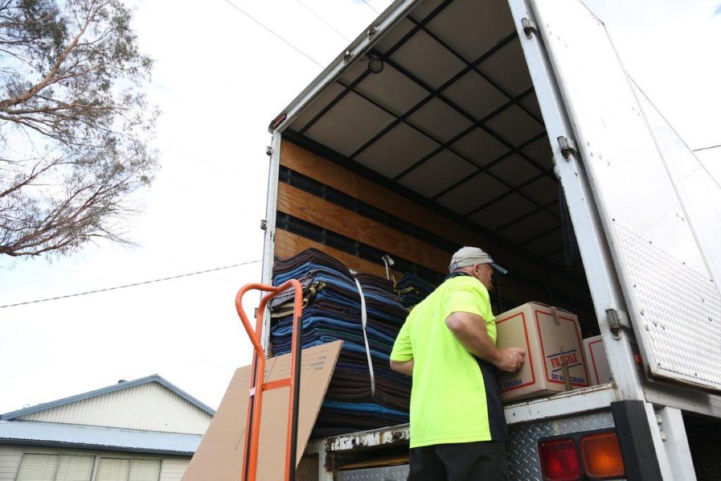 Packers and movers crew loading boxes onto a removal truck